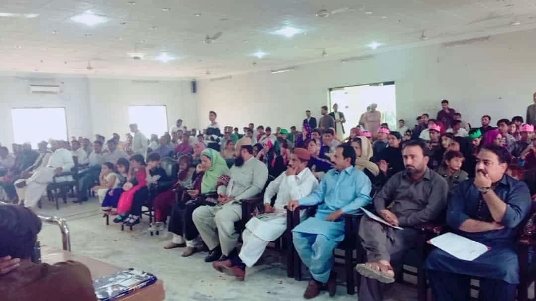 An audience seated together in a hall during a public event.