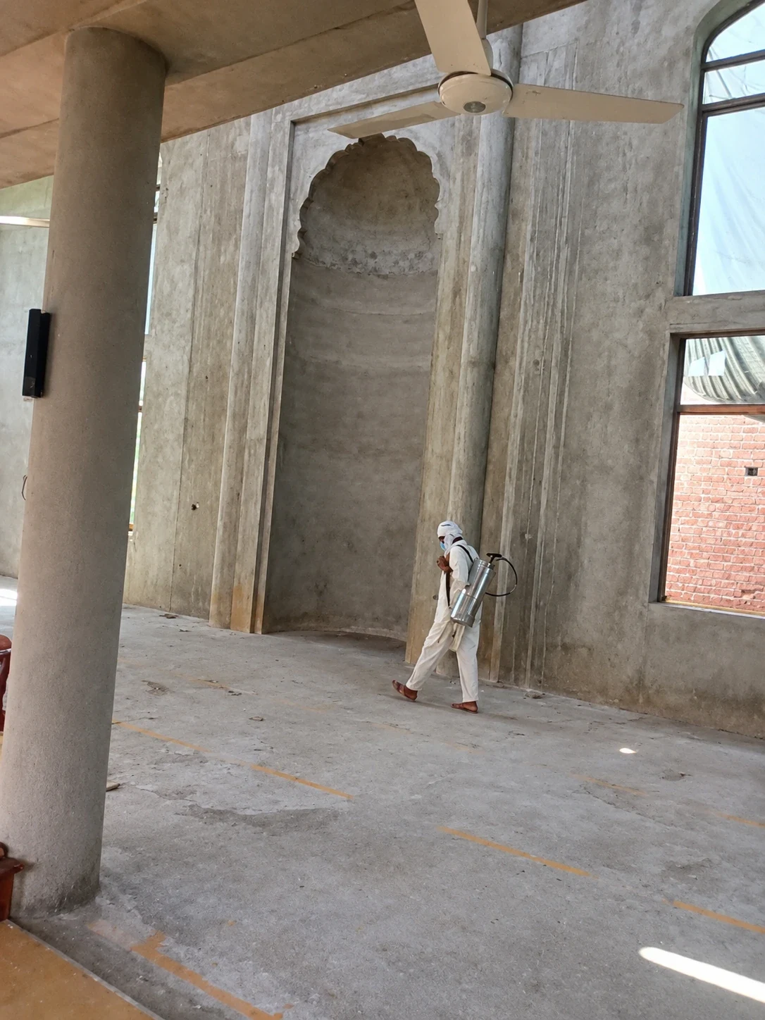 A person dressed in protective clothing in a covered building entrance.