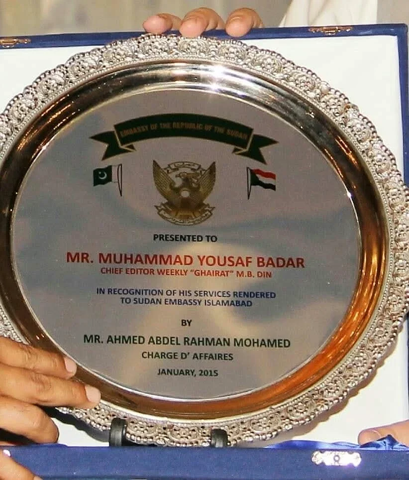 A close view of a round engraved presentation plaque held in a blue case.